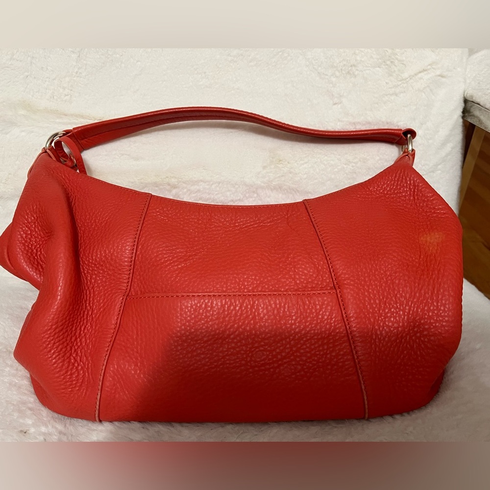 Coral colored over the shoulder bag. Roomy, clean inside.